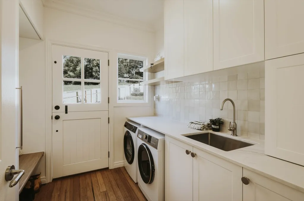 Custom laundry with white cabinetry and timber floors