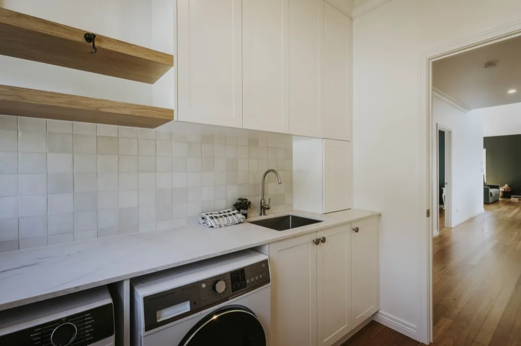 Custom laundry with timber shelves and tile splashback
