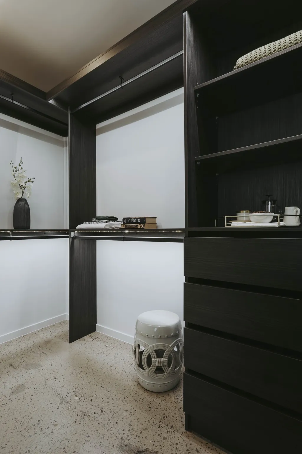 Custom dark walk-in robe with shelving and drawers